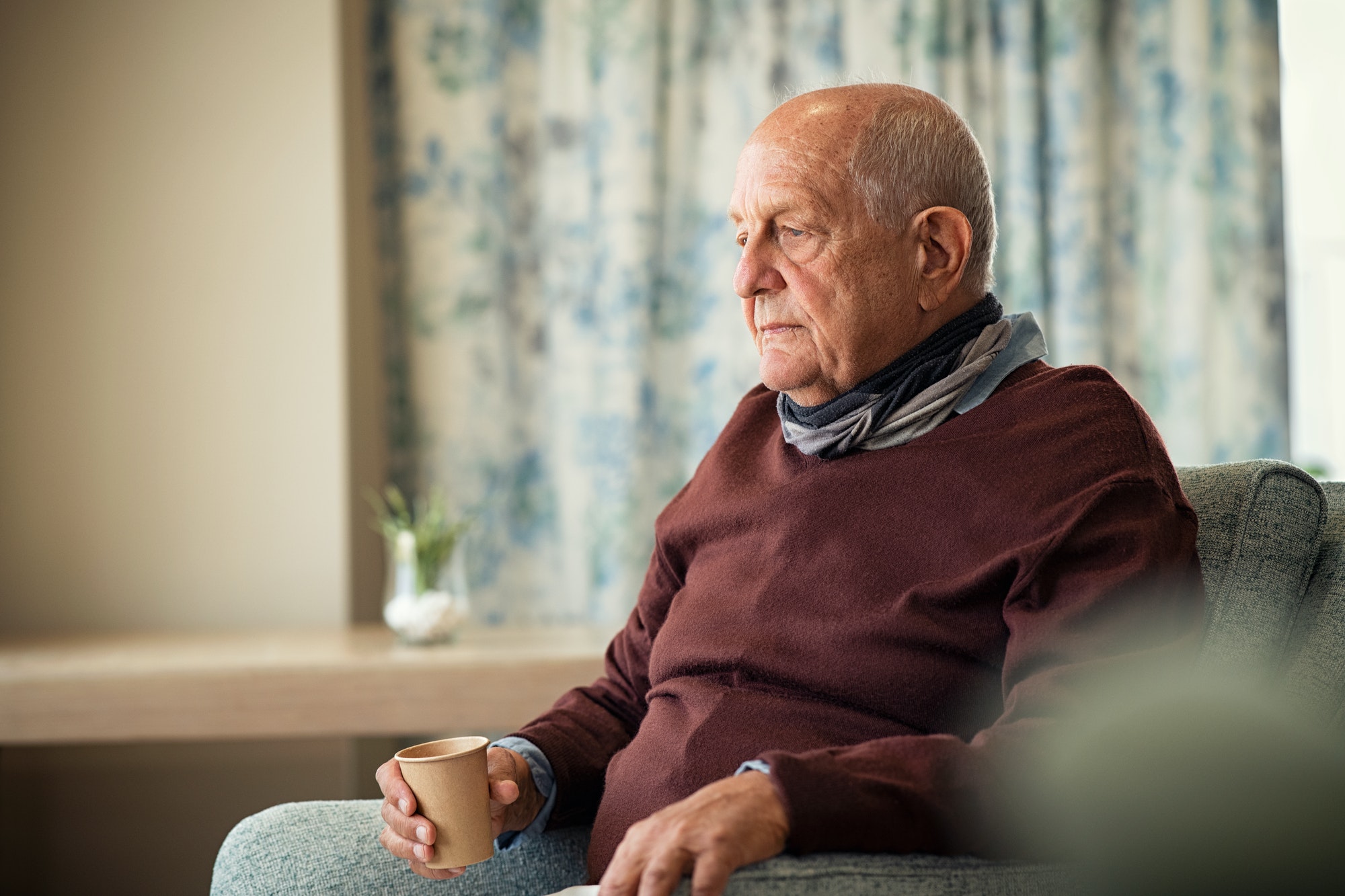 Sad senior man drinking alone